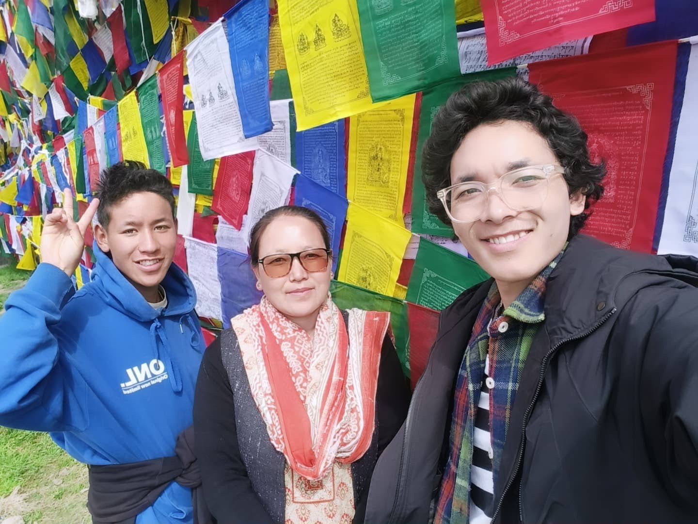 The family behind 7 Pines Homestay among prayer flags in Kaza